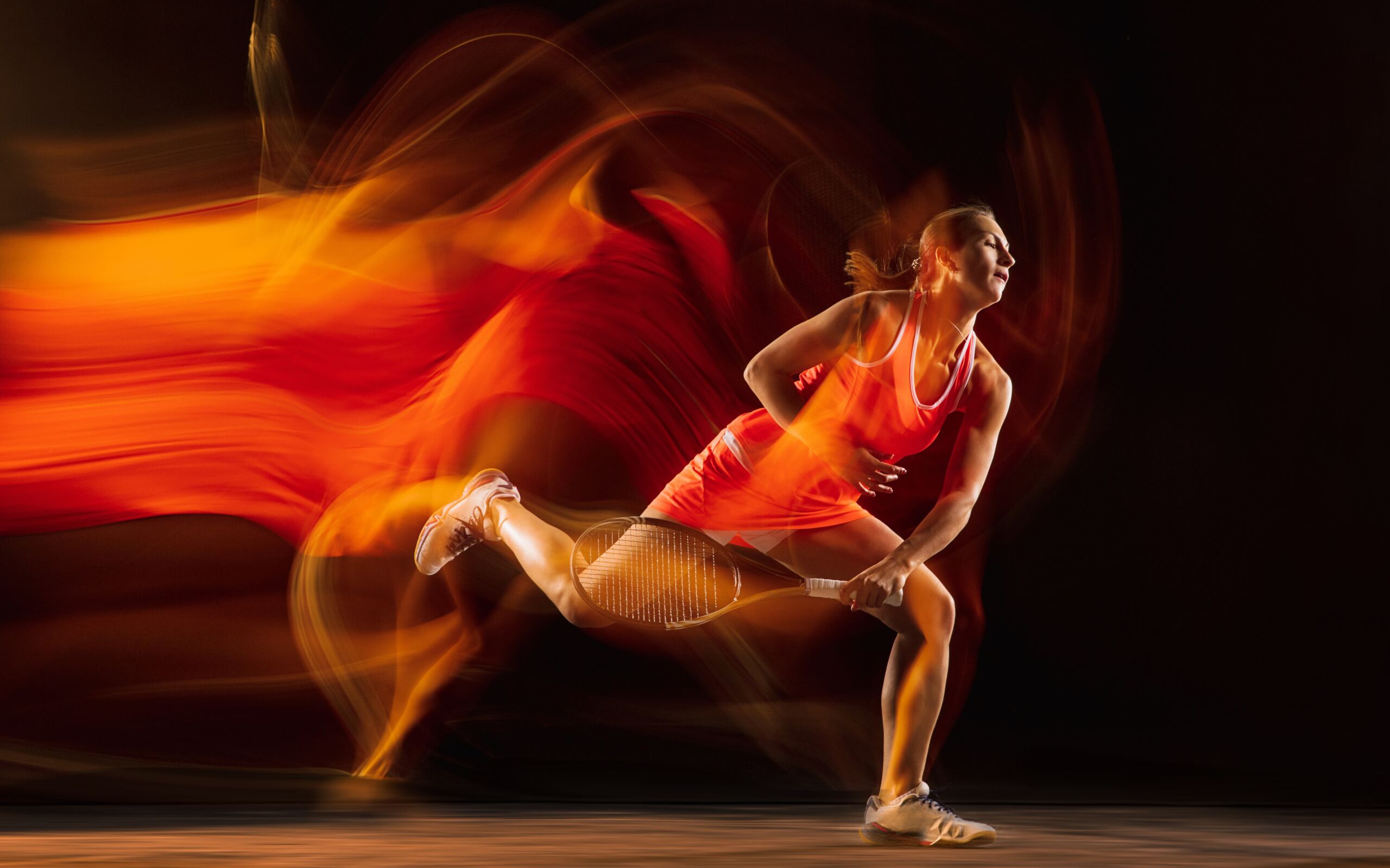 Fire flame. Professional female tennis player training isolated on black studio background in mixed light. Woman in sportsuit practicing. Healthy lifestyle, sport, workout, motion and action concept.